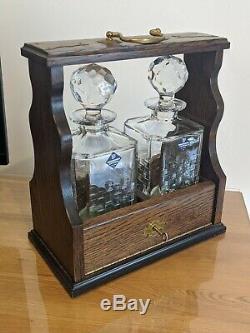 Vintage lockable oak tantalus with key and two Edinburgh Crystal decanters whi